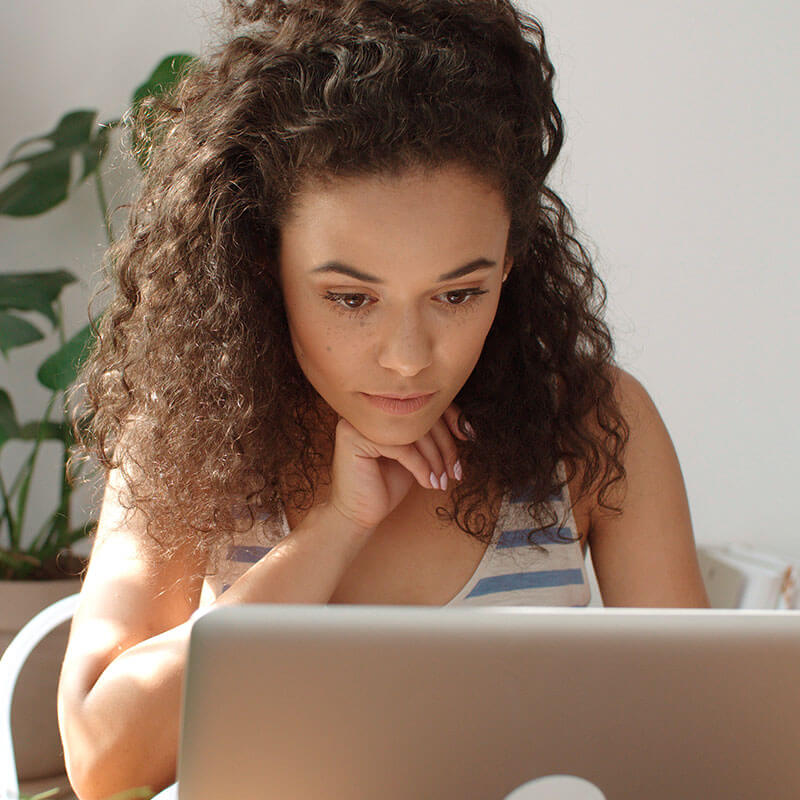 Jeune femme lisant ses emails sur ordinateur